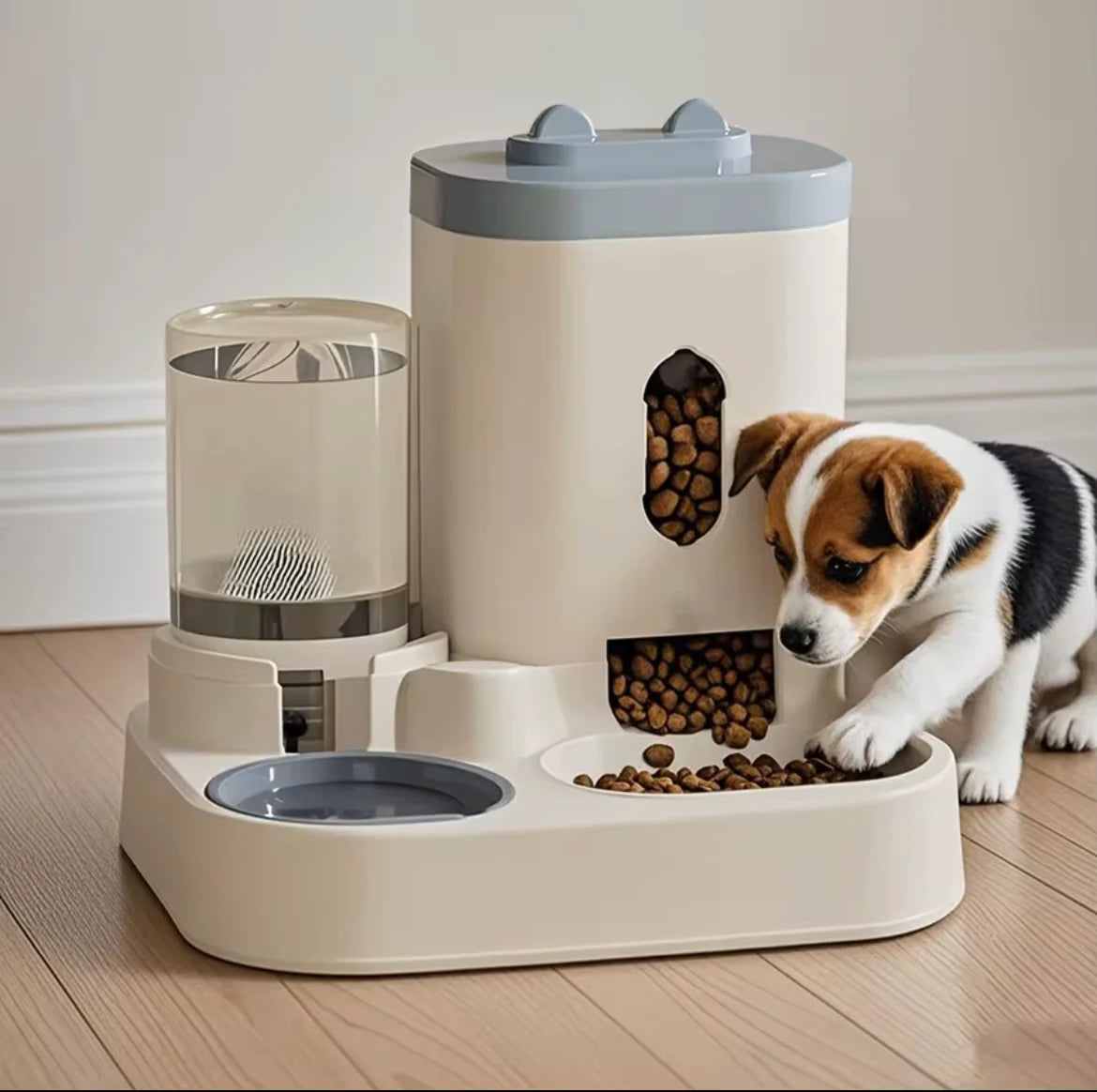 A Jack Russell Terrier puppy eating kibble from a modern cream-colored automatic smart pet feeder and water fountain station on a wooden floor.