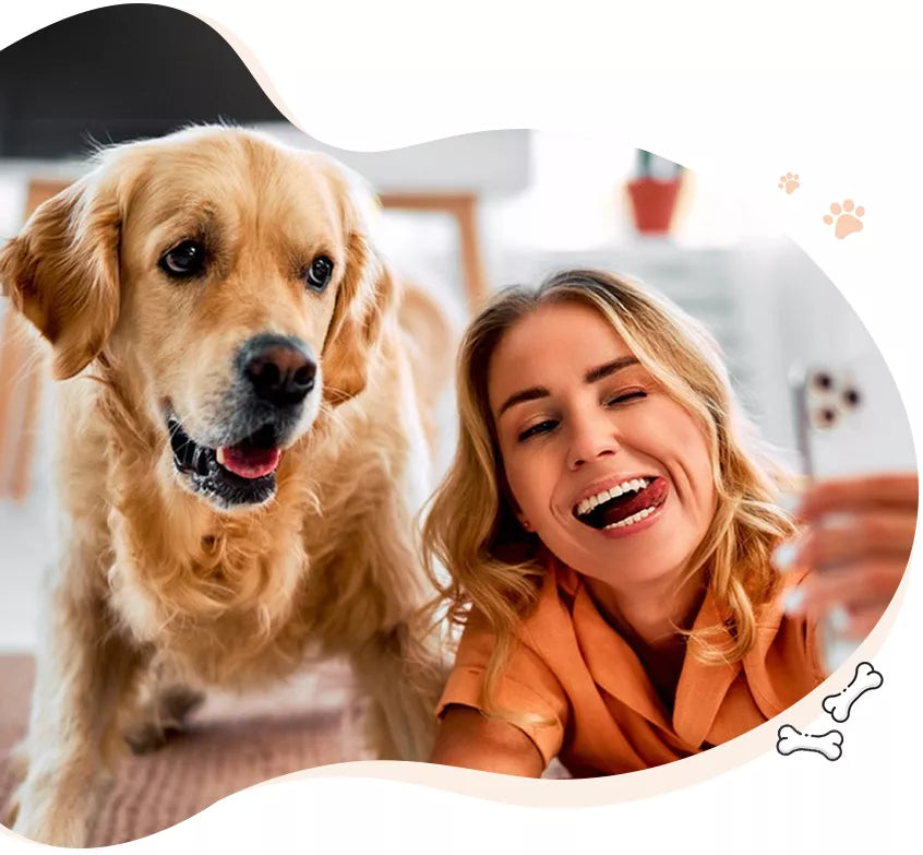 A smiling woman lying on the floor and taking a selfie with a happy, fluffy golden retriever dog in a living room.
